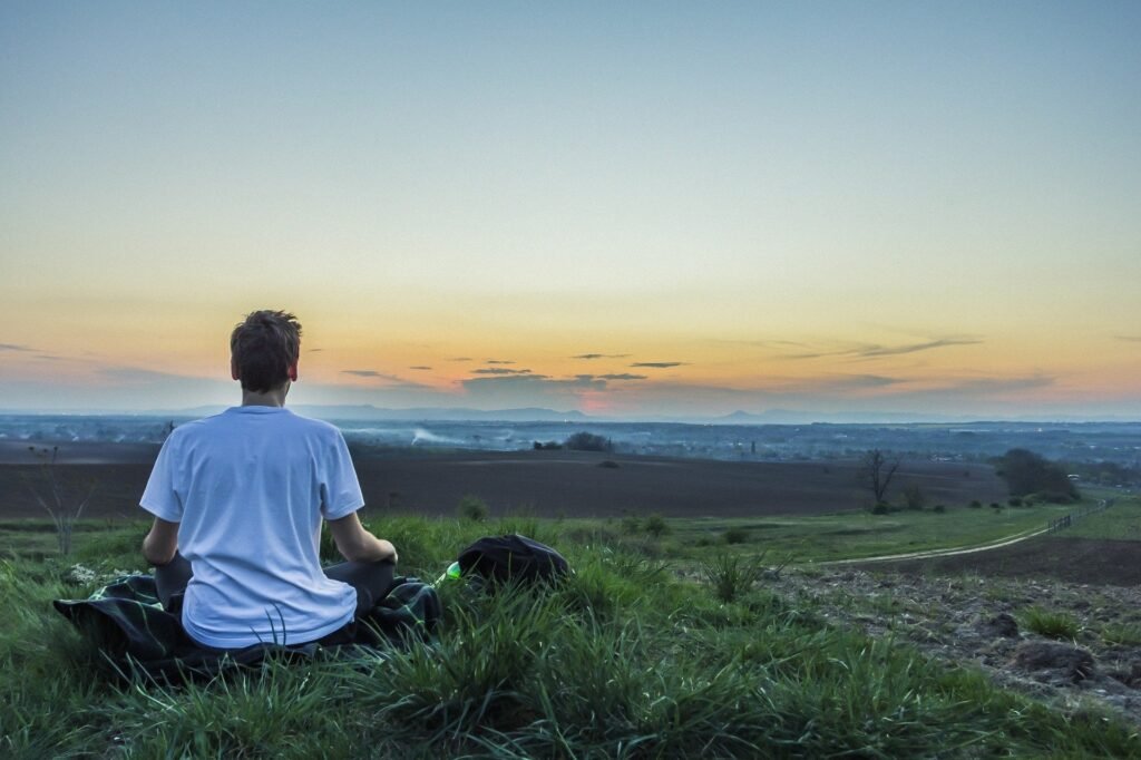 guy-practicing-pranayama-on-an-open-green-field