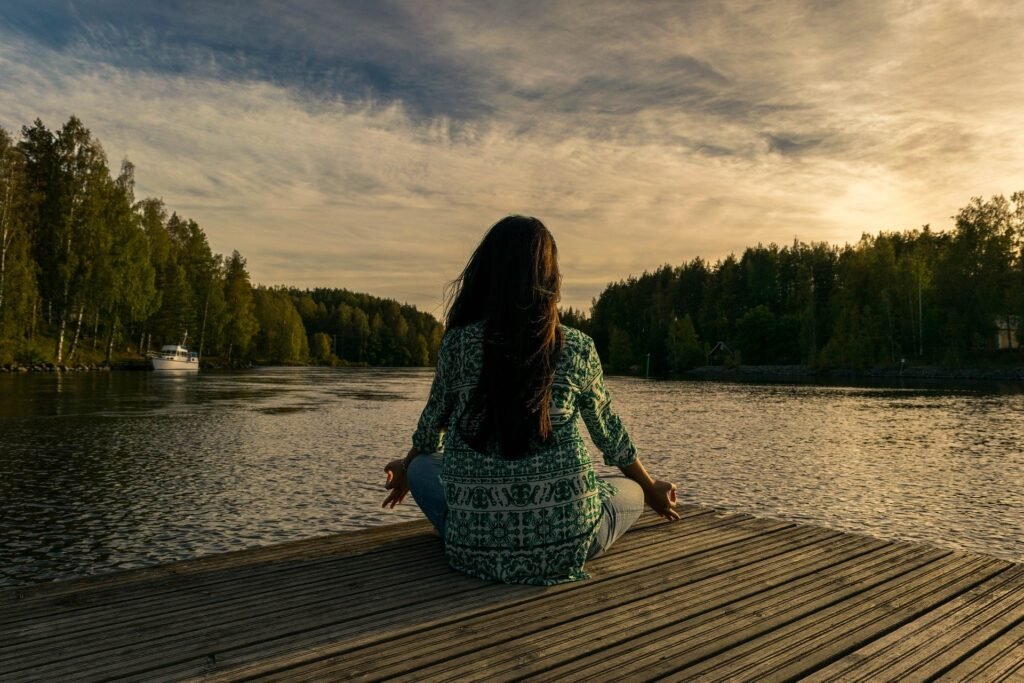 woman-performing-pranayama-on-the-river-bank